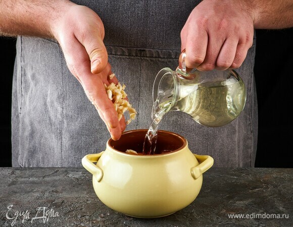 Добавьте немного рубленого чеснока. Количество горшочков зависит от их размера. Влейте в каждый горшочек овощной бульон.