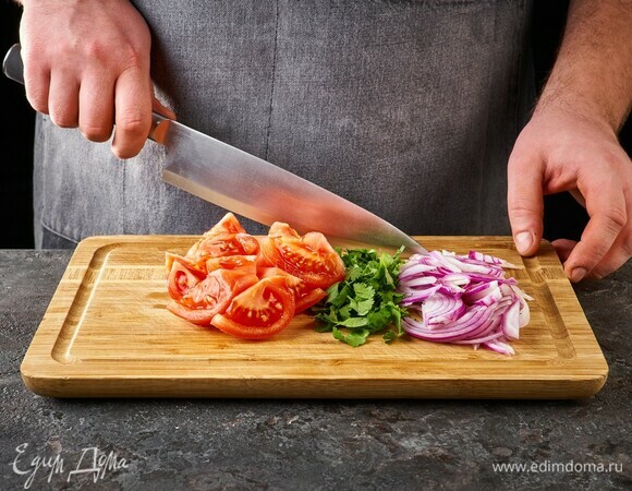 Помидоры нарежьте дольками, красный лук — полукольцами, кинзу порубите.
