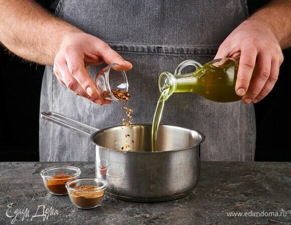 В кастрюлю с толстым дном влейте растительное масло. Добавьте паприку, молотый чили и корицу. Обжаривайте, помешивая.