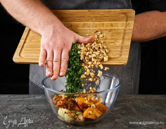 Запеченные овощи выложите в салатник. Посыпьте рубленой зеленью, орешками, перемешайте и подавайте.