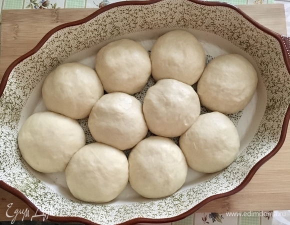 Далее сформировать колобки, выложить в форму для выпечки, накрыть пленкой и оставить на 20–30 минут для подъема. После смазать верх булочек желтком + 1 ст. л. воды, отправить в разогретую духовку на 30–40 минут при 180°C.