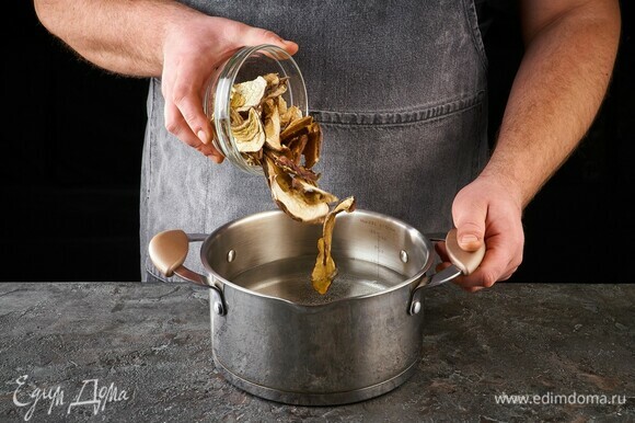 Сухие белые грибы добавьте в кастрюлю с водой, проварите 10 минут. Грибной бульон процедите. Грибы переложите в чистую чашку и при необходимости нарежьте.