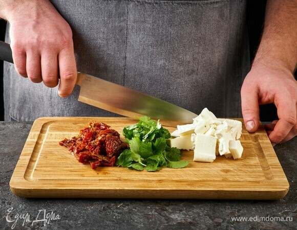 Вяленые помидоры нарежьте тонко, тофу нарежьте крупно, листья кинзы отделите от стебельков.