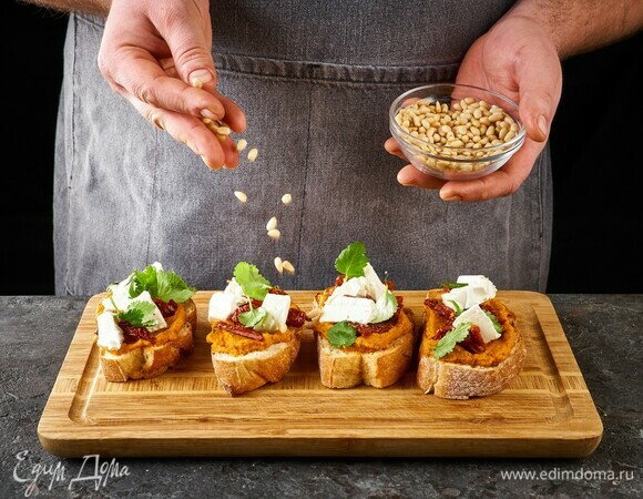 Выложите на икру листья кинзы. Посыпьте кедровыми орешками.