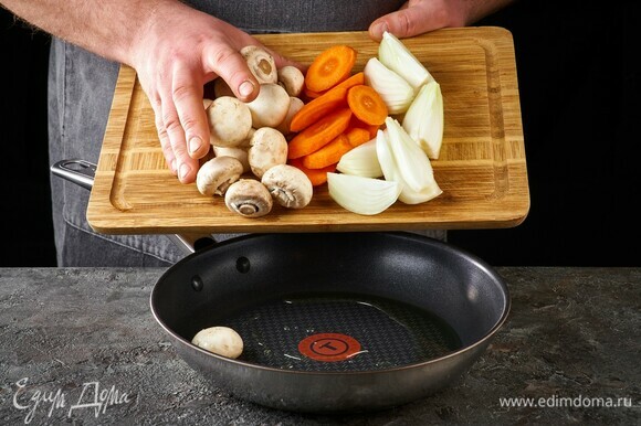 В глубокой сковороде обжарьте на растительном масле лук, морковь и грибы 5–7 минут.