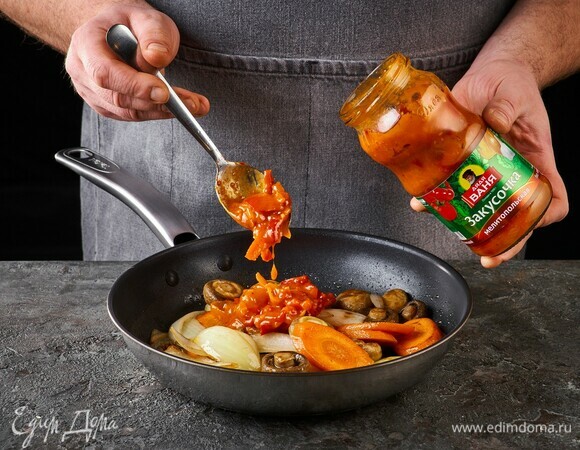 Когда грибы немного уварятся, добавьте закусочку «Мелитопольская» ТМ «Дядя Ваня». Перемешайте, прогрейте.