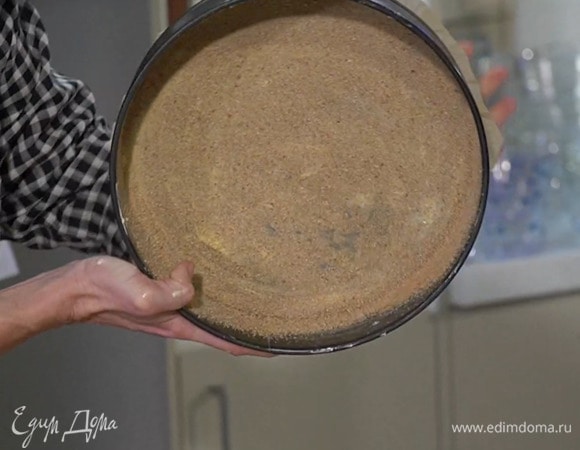 Дно разъемной формы для выпечки выстелить пищевой бумагой, слегка смазать дно и бока сливочным маслом и посыпать сухарями.