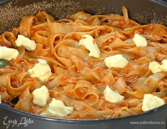 Выложить макароны с соусом в форму и равномерно распределить, сверху разложить маленькие кусочки оставшегося сливочного масла.