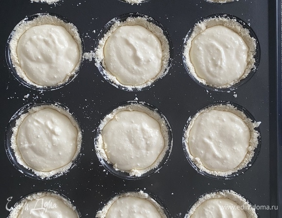 Для начинки смешать венчиком все ингредиенты, слегка взбить. Будет жидкая консистенция. Духовку разогреть до 180°C, режим верх/низ. Нужна форма для кексов, ее не смазывать, руками утрамбовать тесто в виде корзинок. На это уйдет 3/4 теста (крошки), наполнить начинкой до верха.