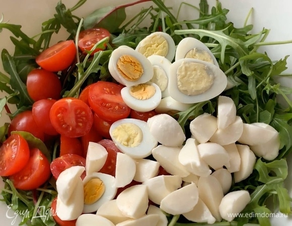 Моцареллу мини также разрежьте пополам и добавьте к остальным ингредиентам.