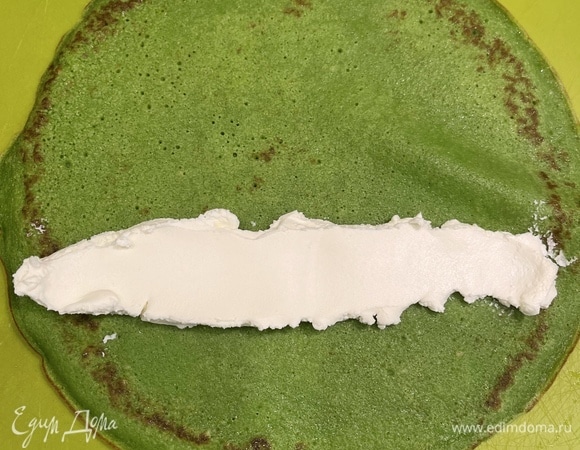 На край блинчика выкладываем полосой творожный сыр, затем — тонко нарезанную рыбу, скручиваем в рулет, нарезаем и подаем.