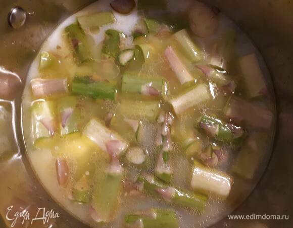 У спаржи отрежьте нижнюю часть. Срежьте верхушки и отложите в сторону. Остальную часть стеблей нарежьте на бруски. Добавьте к луку, влейте бульон (бульон может быть любой — как овощной, так и мясной) и молоко, добавьте соль, доведите до кипения и проварите 10 минут.