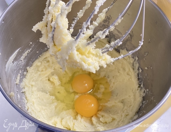 В чаше миксера взбить сливочное масло с сахаром в воздушный крем. Добавить яйца и продолжить взбивать до однородности.