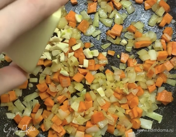 В ту же сковороду с маслом выкладываем нарезанный лук и морковь, обжариваем 5–7 минут. Добавляем чеснок и томаты в собственном соку, накрываем крышкой и тушим около 5 минут.