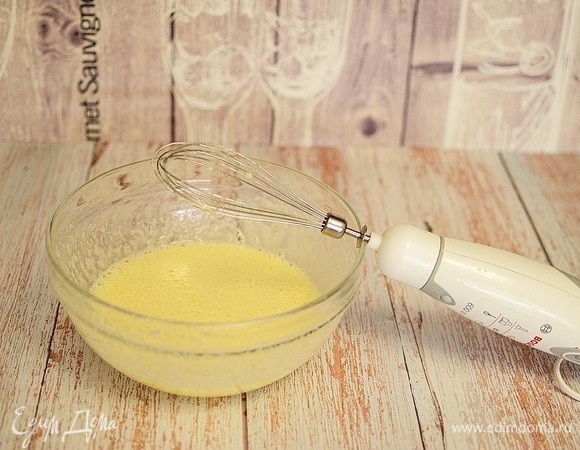 Хорошо взбейте яйца с сахаром до появления пышной пены, добавьте сметану и сливочное масло, хорошо перемешайте.