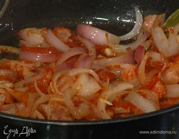 Нарезанный лук добавить в сковороду с беконом и обжарить, затем добавить чеснок, гвоздику, лавровый лист, томатную пасту, все посолить и прогревать на небольшом огне, пока лук не станет мягким.