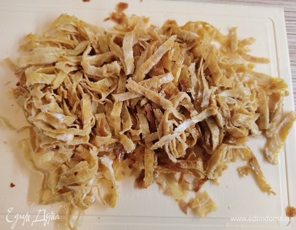 Остудить блинчики, свернуть в рулетики и нарезать тонкой лапшой.