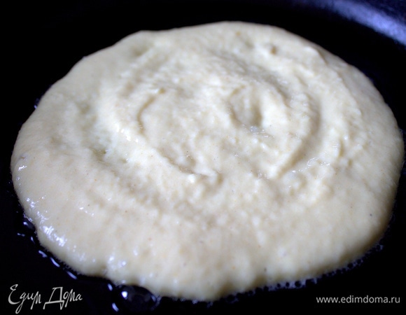 В центр сковороды, разогретой с маслом, влить пару ложек теста.