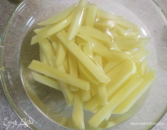Очистить картофель и нарезать соломкой. Для того чтобы блюдо было хрустящим, необходимо промыть и замочить картофель на полчаса в ледяной воде.