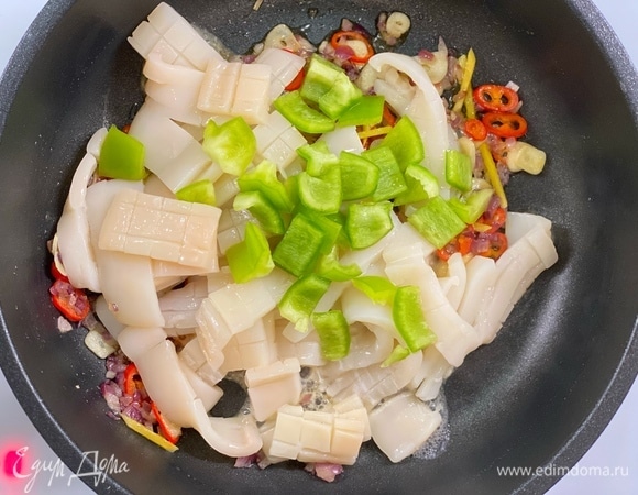 Добавить кальмары и перцы. Обжаривать 2-4 минуты.