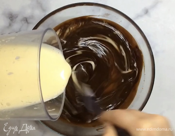 В это время яйца с сахаром взбиваем в белую пену. Соединяем яичную смесь с остывшим растопленным маслом и шоколадом, делаем это постепенно.