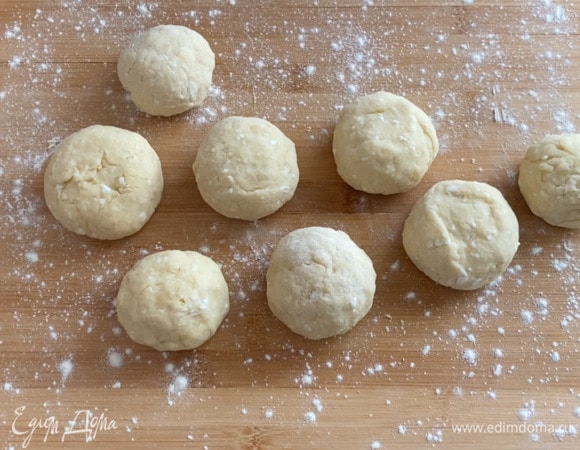 Каждому кусочку придаю округлую форму. Формирую булочки. Выкладываю булочки на противень с пергаментной бумагой. Смазываю булочки желтком и отправляю в разогретую до 180°C духовку на 20–25 минут.