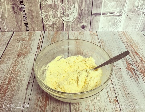 Добавьте в творожную массу яйца и хорошо перемешайте. Далее постепенно всыпайте муку с разрыхлителем, размешивая до однородной консистенции.