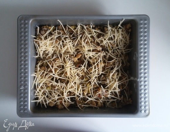 Затем овощной слой лазаньи посыпаем частью сыра. После этого на слой овощей с сыром кладем два с половиной листа теста для лазаньи (чтобы вся овощная начинка была закрыта листами теста) и снова — часть соуса, слой овощной начинки и слой сыра. После чего кладем еще слой из листов теста и смазываем их оставшимся соусом бешамель. После чего разогреваем духовку до 180°C и ставим в нее форму с лазаньей на 30 минут.