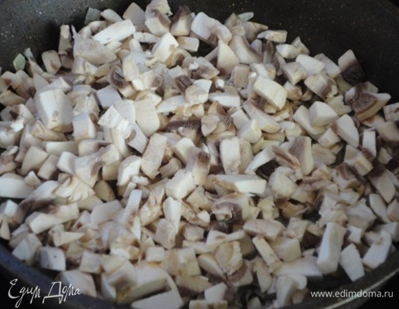 Лук нарезать мелкими кубиками и потомить до прозрачности с 2 ст. л. растительного масла. Добавить также мелко нарезанные шампиньоны и потушить 3–4 минуты. Убрать с огня и остудить.