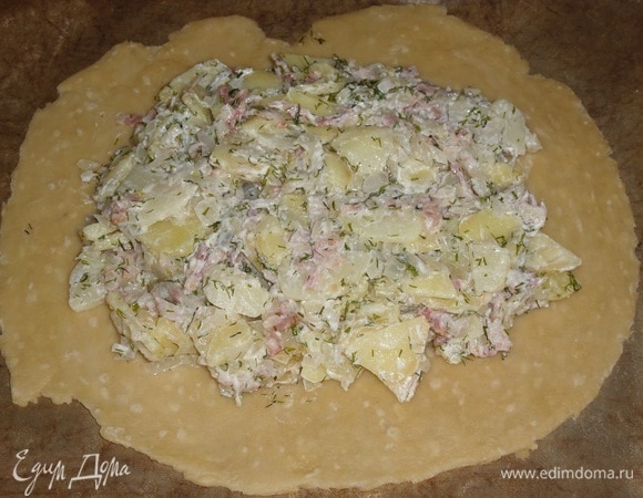 Выкладываем лепешку на противень, застеленный ковриком для выпечки. Выкладываем начинку, немного не доходя до краев лепешки.