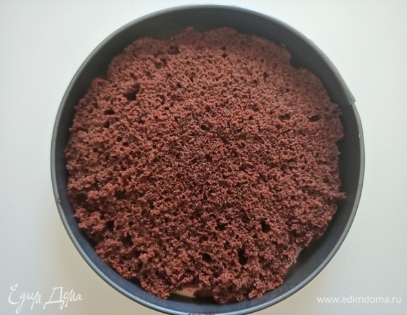 Теперь необходимо приготовить пропитку. Для этого соединить свежесваренный кофе с водой и ликером. Разрезать бисквит пополам. Уложить одну часть бисквита на дно разъемной формы, пропить и выложить половину крема.