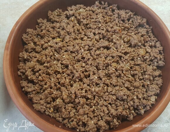 Лук мелко нарезать и обжарить до золотистого цвета. Потом добавить к нему фарш и жарить до выпаривания жидкости. Посолить и поперчить по вкусу, переложить в форму для запекания.