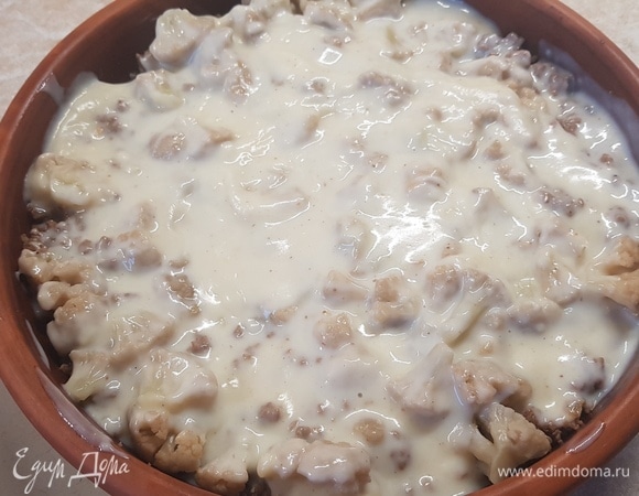 Залить соусом капусту с фаршем. Поставить на 20 минут в духовку запекаться при температуре 200°C. Сыр натереть на мелкой терке. Посыпать сверху и запекать еще 5 минут.