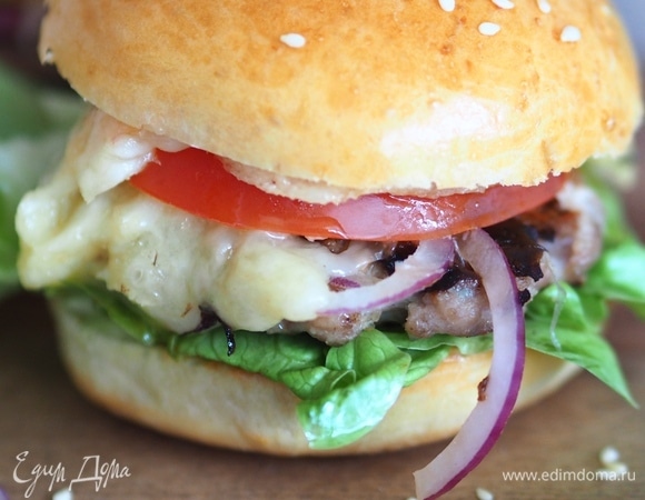Собираем бургер. Булочку разрезать пополам, подсушить на сухой сковороде, смазать соусом, сверху — листья салата, котлета, кольца лука, помидора и слегка поджаренный сыр. Накрываем второй половинкой булочки и наслаждаемся вкуснейшим натуральным бургером. Приятного аппетита!