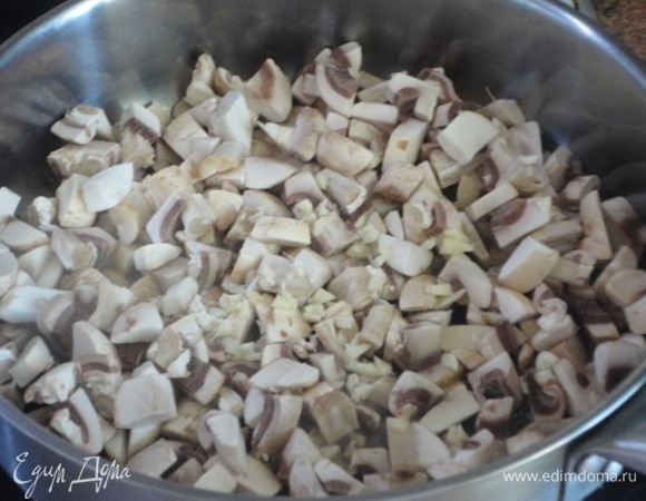 Шампиньоны нарезать довольно мелко, чеснок порубить и обжаривать на оливковом масле 10 минут, пока жидкость не выпарится.