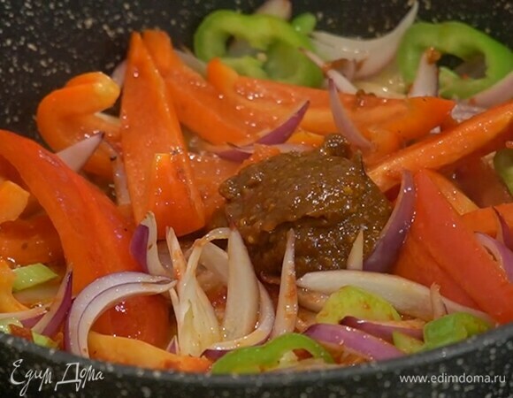 Переложить окорочка в жаропрочную керамическую форму, а в сковороду выложить все нарезанные овощи, добавить томатную пасту, аджику, помидоры в собственном соку, все посолить, перемешать и обжарить.