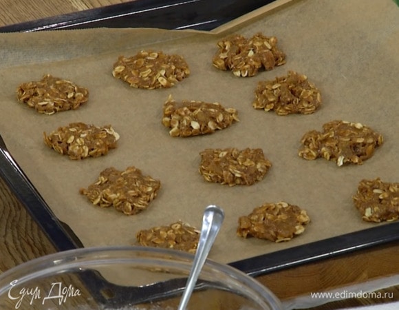 Сформировать из овсяного теста небольшие лепешки и выложить на выстеленный бумагой для выпечки противень.
