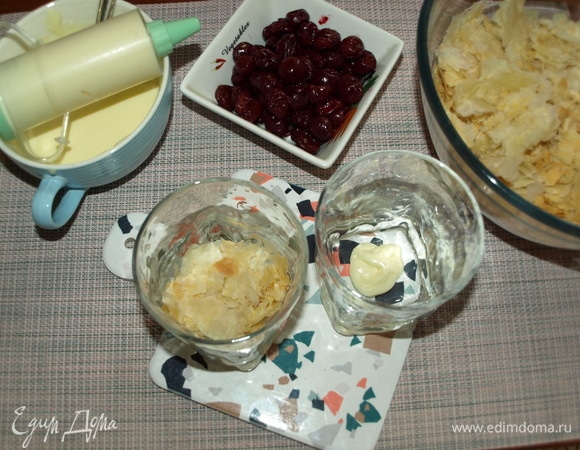 На дно каждого стакана кладем немного крема и добавляем крошку из коржа.