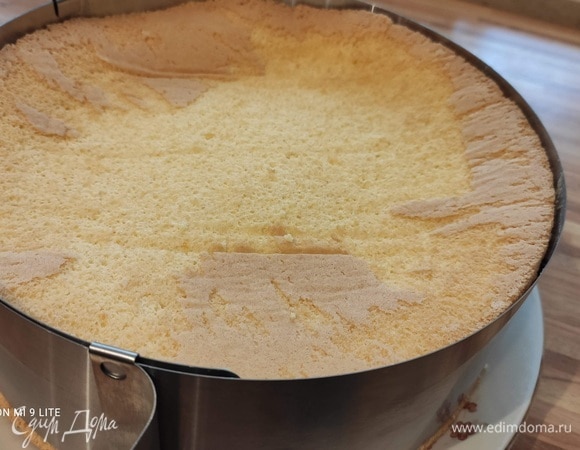 Перед сборкой нужно приготовить пропитку: соединить все ингредиенты в ковшике и довести до кипения, дайть остыть. Разрезать бисквит на две равные по толщине части. Выложить на блюдо один корж, пропитать его сиропом. Установить вокруг коржа кольцо. По возможности выложить ацетатной пленкой.