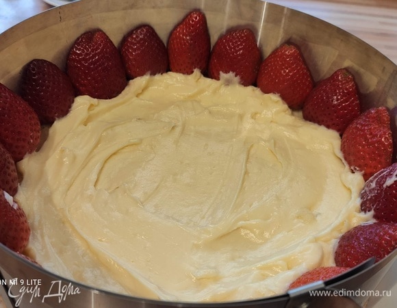 Выложить клубнику по краю срезанной стороной наружу. С помощью кулинарного мешка или просто ложкой выложить небольшое количество крема позади клубники и на дно торта.