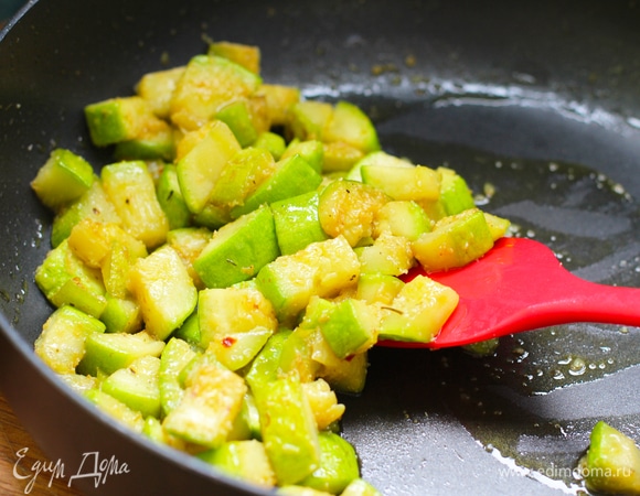 Цукини пожарить в сковороде на оливковом масле до румяного цвета (около 6–10 минут). Посолить, добавить измельченный чеснок.
