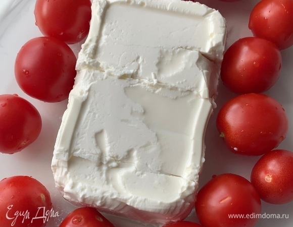 Выложите фету и томаты черри в форму для запекания.