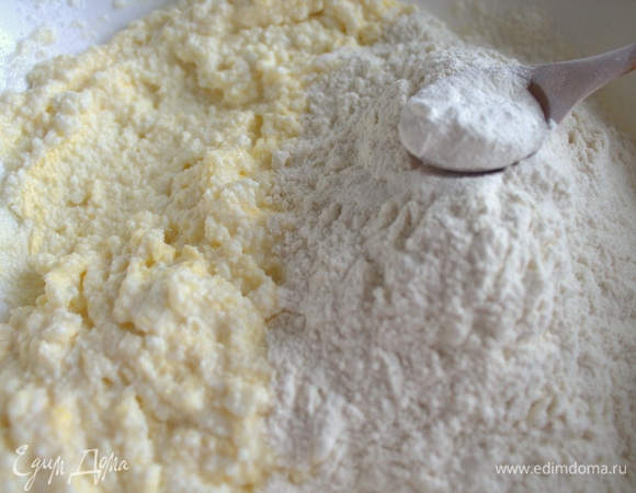 Всыпать муку с разрыхлителем и солью. Муки может уйти больше, если творог слишком влажный.