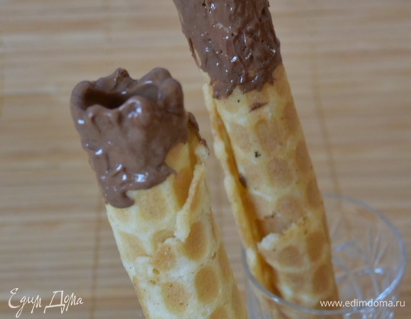 Теперь переходим к декору. Растопить шоколад (черный и белый). Один конец трубочки окунуть в белый шоколад. Поставить в морозилку для застывания. Затем окунуть другой конец в белый шоколад.