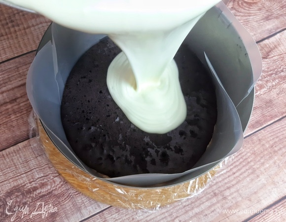 У меня форма диаметром 18 см. Бортики выкладываем ацетатной пленкой. Но у меня ее не было, и я вырезала две полоски из пластикового скоросшивателя. Кладем бисквит. Выливаем сливочную смесь. Аккуратно потрясем, чтобы все равномерно распределилось. Накрываем сверху пищевой пленкой. Убираем в холодильник для стабилизации на пару часов.