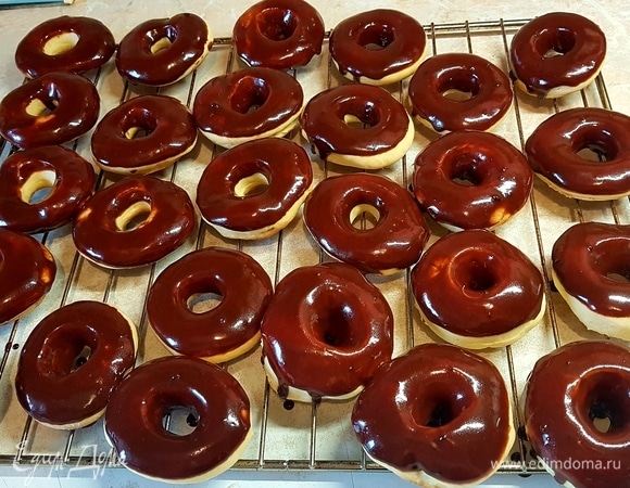 Для глазури в сотейнике растопить масло с молоком, добавить какао и сахар. На маленьком огне готовить до растворения сахара. В глазурь окунуть пончик и оставить на решетке до застывания.