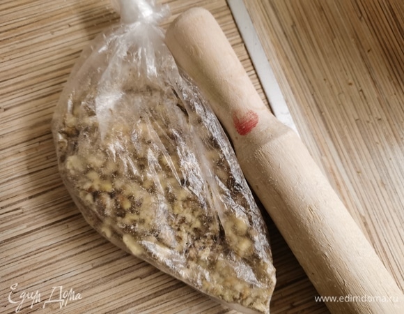 Грецкие орехи измельчить. Я сложила в пакет и измельчила скалкой.