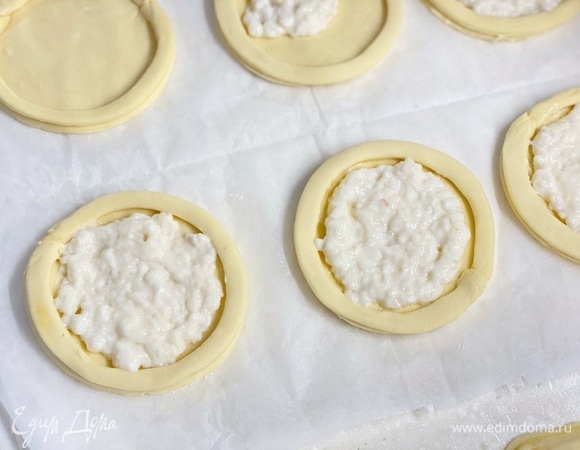 На каждый круг по краю выложить полоску из теста. В середину положить немного крема.