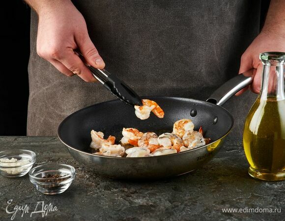 Креветки разморозьте. Посолите, поперчите. Выложите на сковороду с растительным маслом.