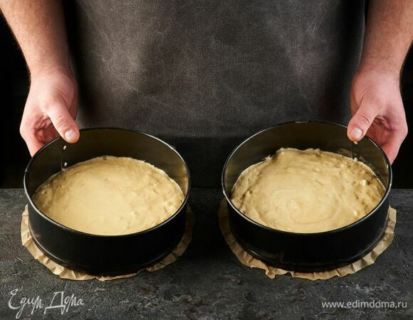 Дно двух форм диаметром 22 см застелите пекарской бумагой. Вылейте тесто и запекайте при 180°C около 30 минут, до сухой шпажки.